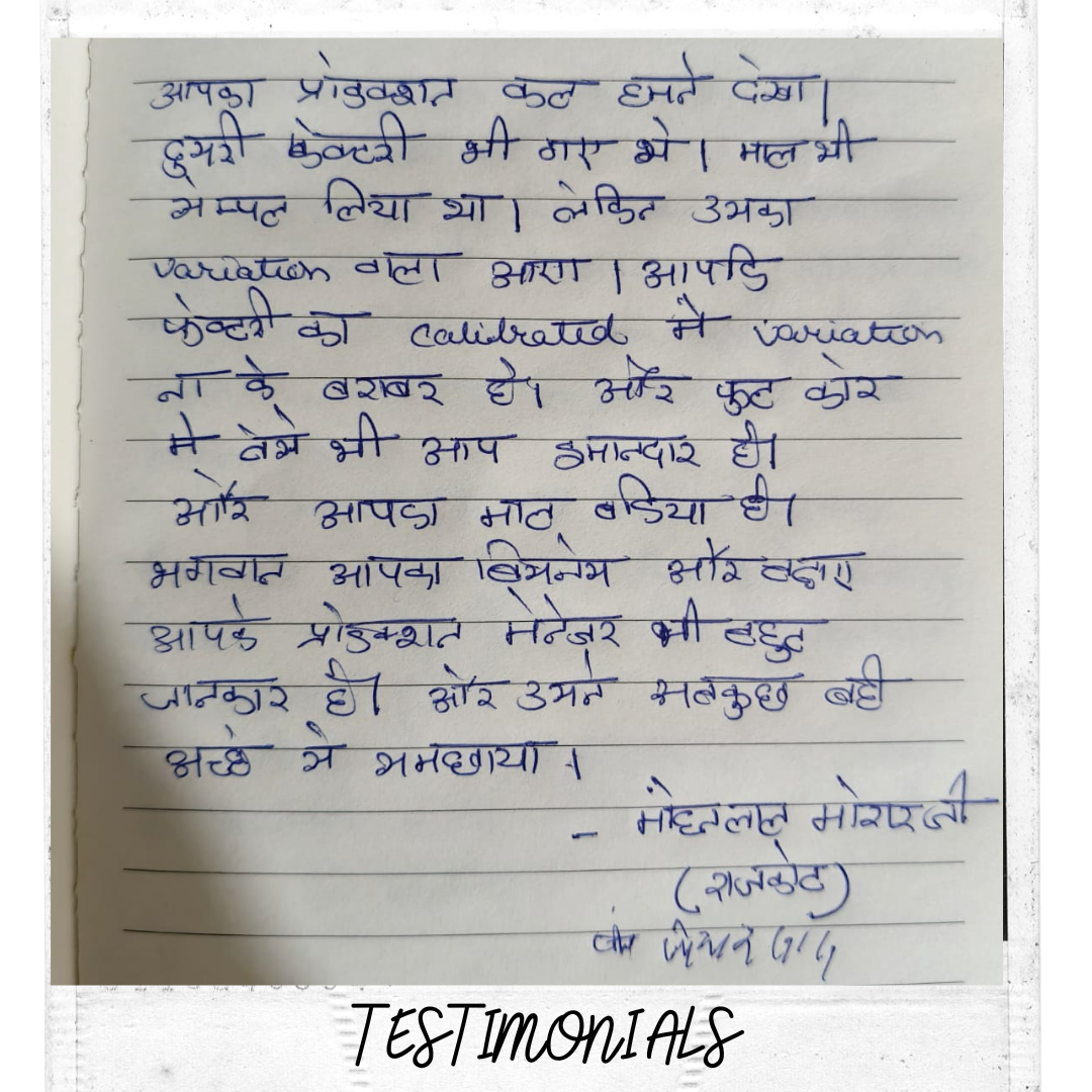 Three men standing in an indoor event, two wearing orange turbans and one in a striped shirt, with chandeliers and peach curtains in the background